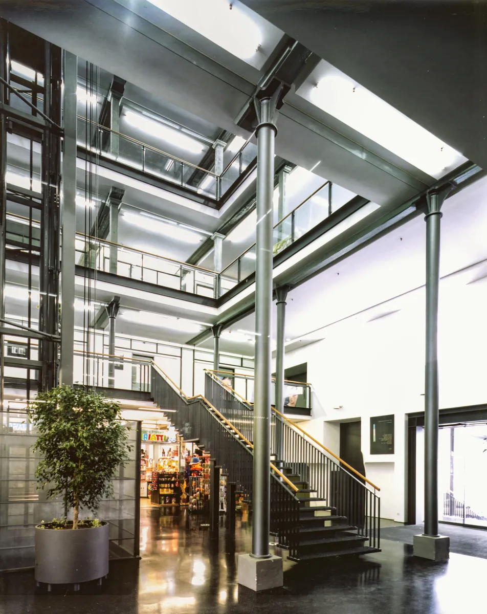 Lichtdurchflutetes Innenatrium der Lünersee Fabrik mit Stahlstützen, Galerien und offener Treppe